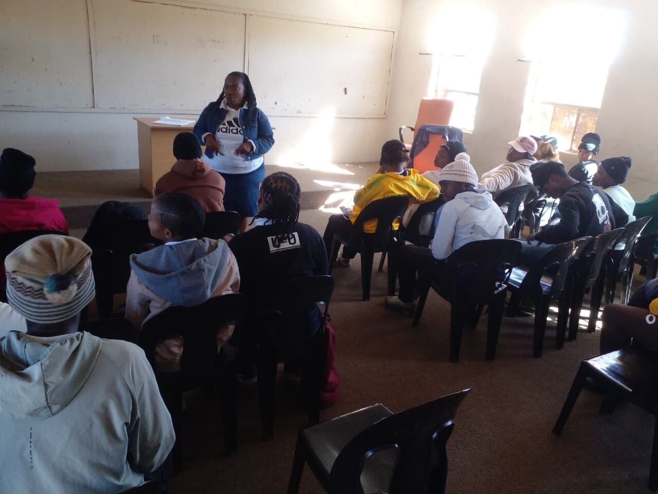 A facilitator presenting to community members at the centre